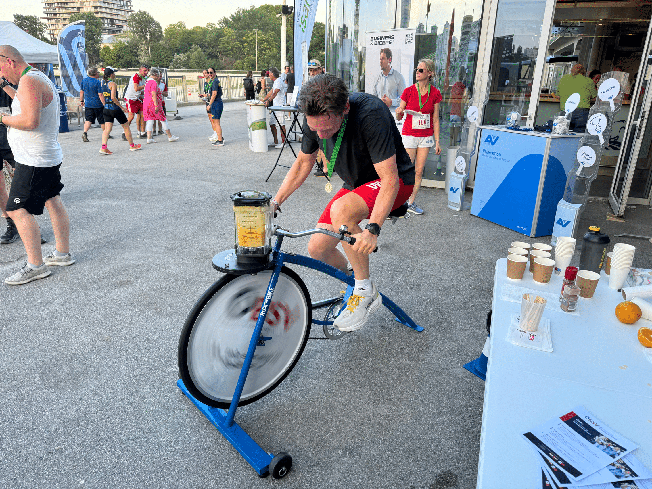 Mann fährt auf einem Smoothiebike und mixt einen Smoothie vor dem Stand von Firmen Sport Austria.