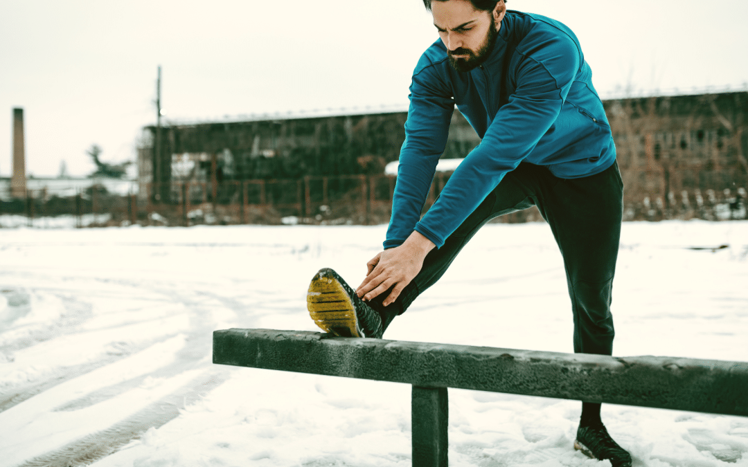 Mann beim Stretching in Winterlandschaft